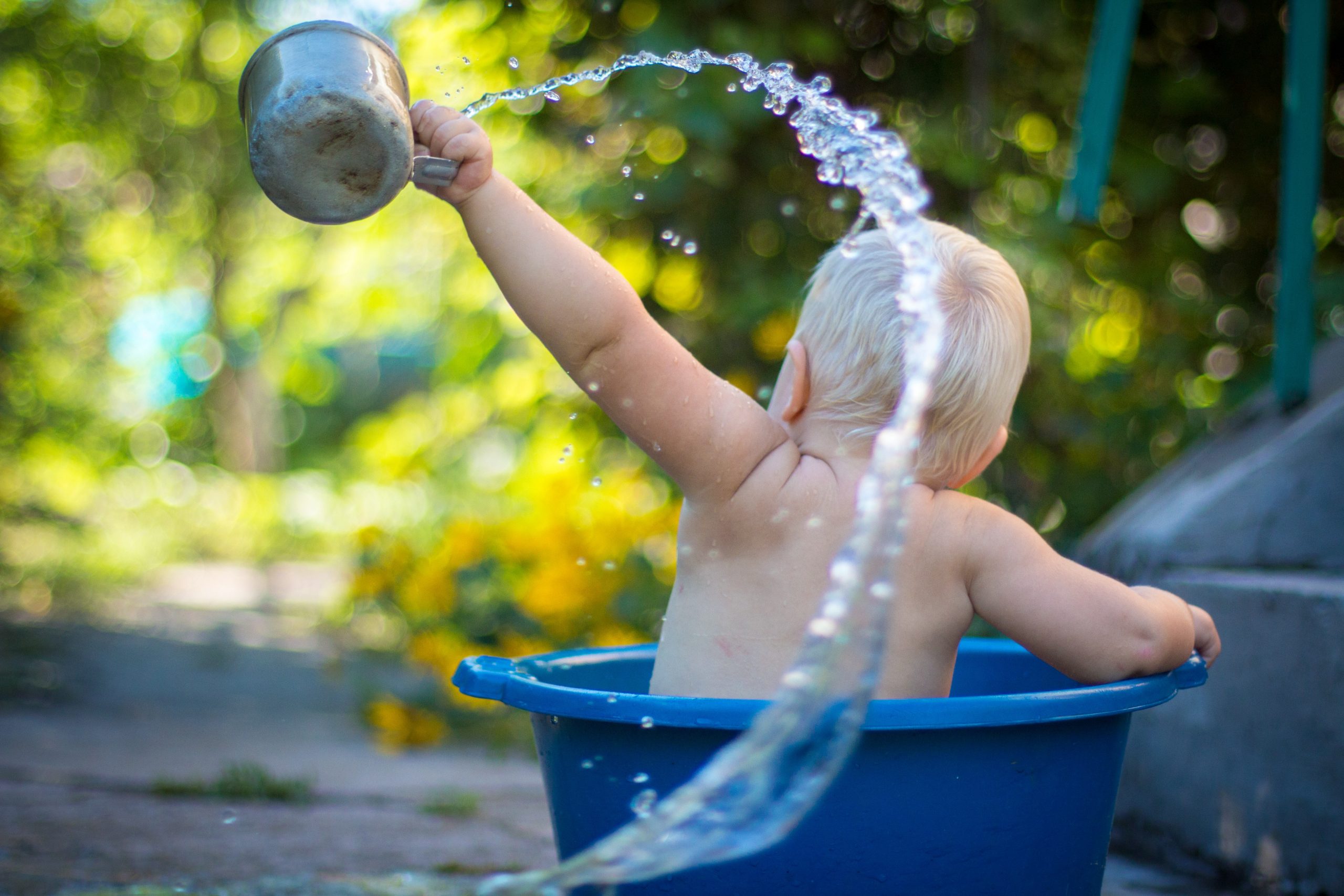 Baby having a cooling bath as bedtime on a hot day