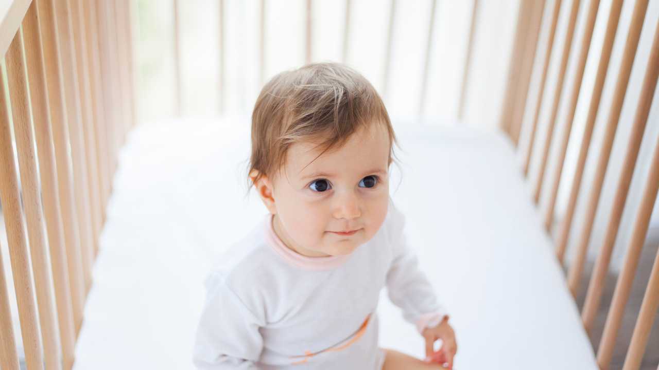 baby sitting in cot as not sleeping and waking every hour at night