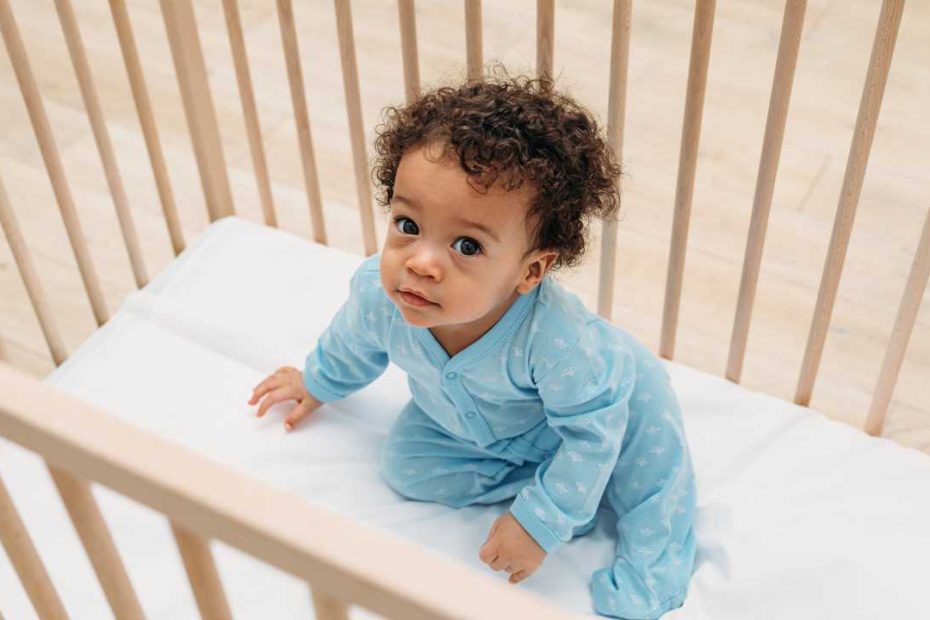 baby sitting in cot ready to work with holistic sleep coach