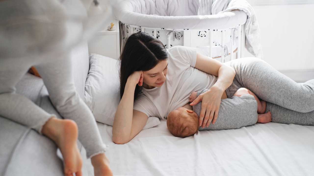 baby being nursed to sleep at bedtime lying down on bed