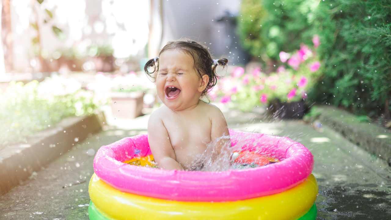 baby in summer cooling down in a paddling pool